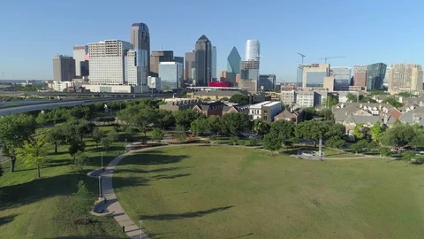 Camera flies low from Park towards Dallas skyline. nice urban and greenspace mix Vidéo 74858282