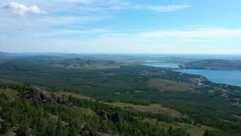 The camera flies from the mountains to the lakes downhill. 스톡 동영상 112097530