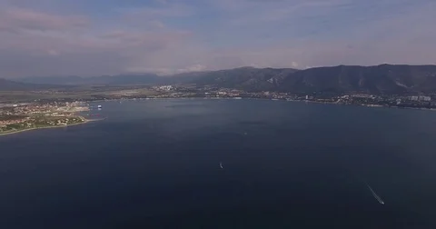 The camera flies over the blue bay, sailing yacht, in the background the Stock Footage 82802201