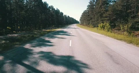 The camera flies over an empty road on a sunny day Stock Footage 146700986