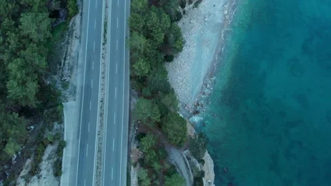 The camera flies over an empty road located on the seashore in the evening Stock Footage 227708928