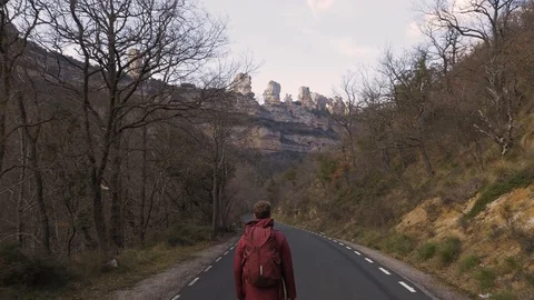 Camera flies over explorer walking toward Orbaneja Del Castillo Stock Footage 102510981