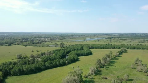 Camera flies over green fields trees and river. Vidéo 111242904