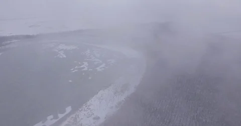The camera flies over the lake and snow-covered forest in the fog Stock Footage 83579611