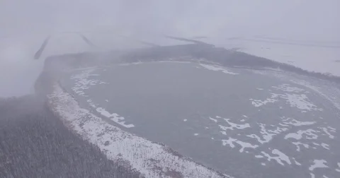 The camera flies over the lake and snow-covered forest in the fog, 4K Stock Footage 83580874