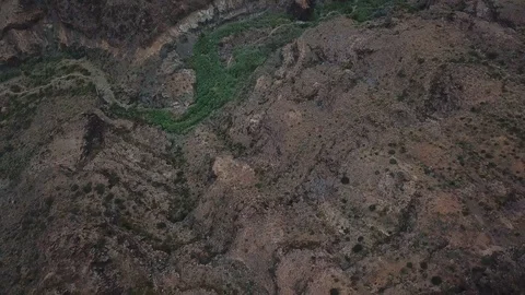 Camera flies over the mountain ridge with forest line meandering between rocks Stock Footage 94117244