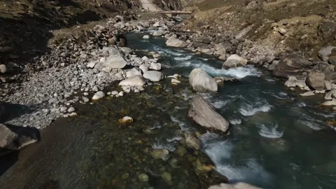 The camera flies over a mountain river in a mountainous area flying under Stock Footage 171295344
