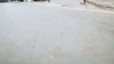 The camera flies over the road, the guys' legs run past the camera and jump Stock Footage 120422959