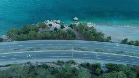 The camera flies over the road located on the seashore in the evening. Stock Footage 227576496
