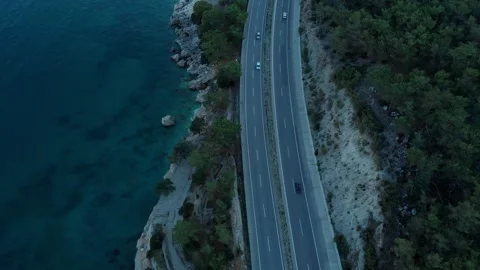 The camera flies over the road located on the seashore in the evening. Stock Footage 227709142