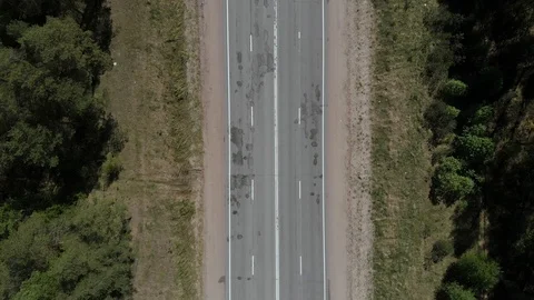 The camera flies over the road in the woods, the camera shoots down. Aerial view Stock Footage 108136379