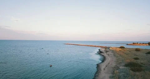 Camera flies over sandy beach towards to breakwater at sea Stock Footage 100703592