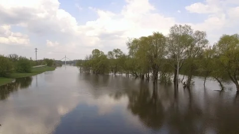 The camera flies over the spill on the river, in the distance a bridge Stock Footage 114137239