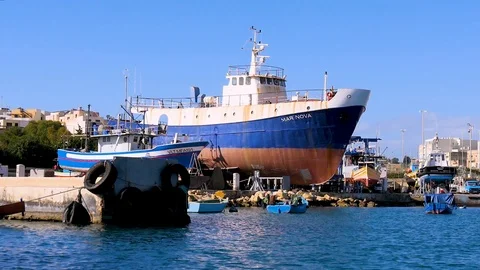 The camera flies over the water with a view of two ships near the shore on land Stock Footage 102045355