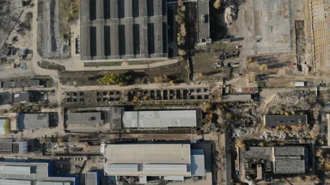 The camera flies parallel to the ground above the metal plant. Stock Footage 97135094