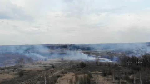 The camera flies through the smoke of burning fields in the direction of the Stock Footage 106350513