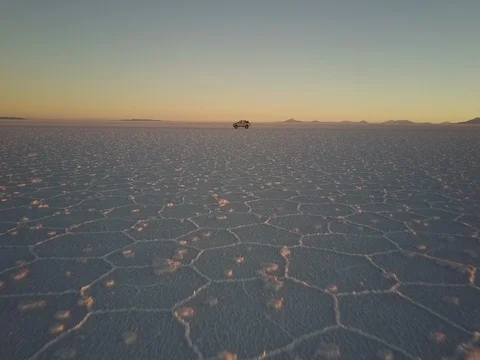 Camera flies towards pickup parked on the Salar de Uyuni salt flats at sunset Stock Footage 83292458