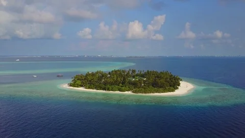 The camera flies towards round tropical island resort hotel with white sand palm Stock Footage 77550070