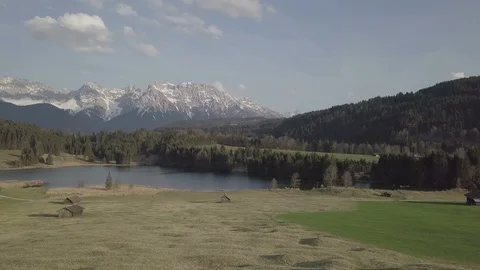 Camera flight above green slope with the houses and the mountain Stock Footage 89761842