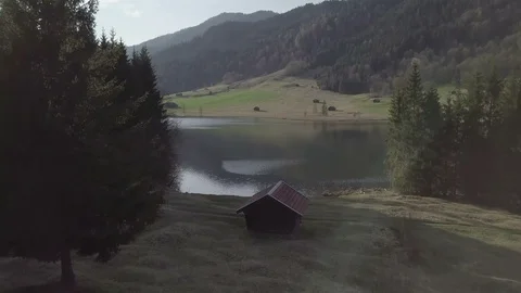 Camera flight above the house next to the lake in the mountain landscape Stock Footage 89760972