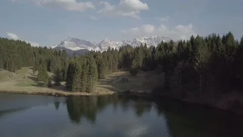 Camera flight above the lake towards the house in the mountains landscape Stock Footage 89760555
