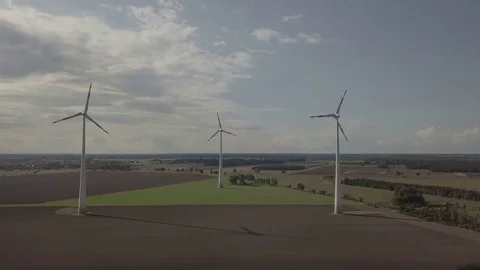 Camera flight along three working windmills. Energy Production - Aerial Stock Footage 83821400