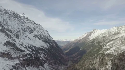 Camera flight between the snowy mountains - Aerial Stock Footage 83861642