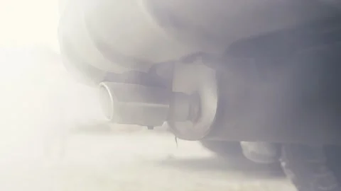 Camera flyby around the smoke-steaming exhaust pipe of a car Stock Footage 152427676