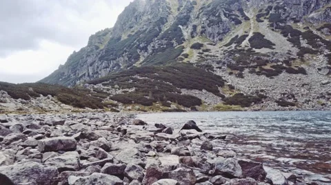 Camera flying to the lake shore in high mountings. Stabilized Shot, POV, 4K. Stock-Footage 55870681