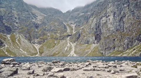 Camera flying to the lake shore in high mountings. Stabilized Slow-Mo, POV. 库存影片 55873833