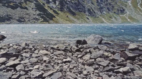 Camera flying to the lake shore in high mountings. Stabilized Slow-Mo, POV. 스톡 동영상 55877971