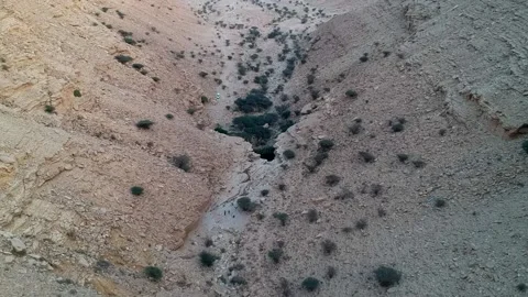 Camera flying over a canyon with a small natural Sha'ib Luha Pool Stock Footage 152700267