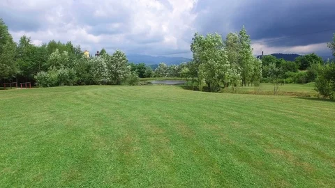 Camera flying over a golf course towards lake 動画素材 117793803