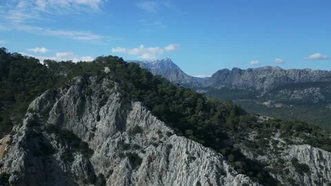 The camera flying off over the mountain and offers a view of mountains behind it Stock Footage 233287357