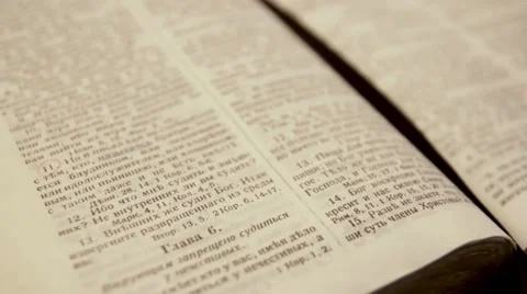 Camera flying over open Bible on Russian language Stock Footage 65596417