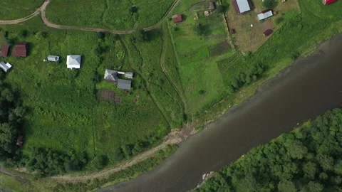 Camera flying over small village by river in countryside Vídeo Stock 308527223