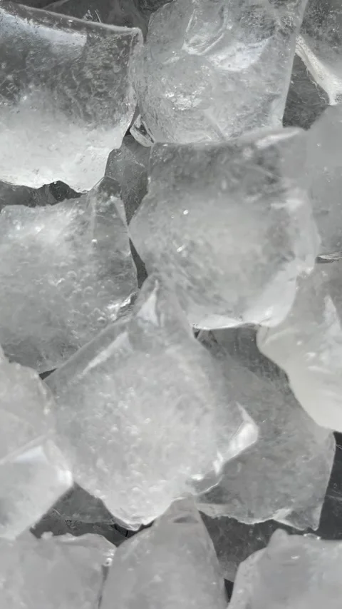 Camera flyover above large clear ice cubes macro texture. Vertical Stock Footage 336506979