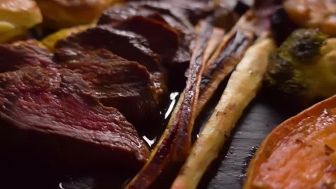 Camera Flyover of Sunday Roast with Roasted Vegetables and Juicy Beef Stock Footage 334338231