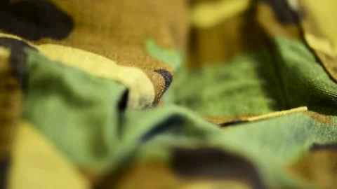 Camera focus  going through military clothes Stock Footage 184926475