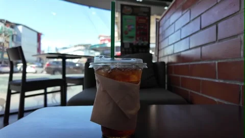 Camera focus on iced tea inside cozy cafe Stock Footage 325650243