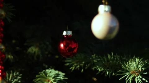 Camera focus on a red glass bead. Toys on a green tree, objects on the sides are Stock Footage 296401768