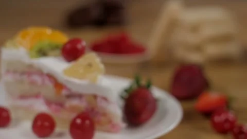 Camera focus on a slice of creamy sponge cake decorated with fresh fruits Stock-Footage 153199646