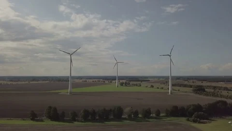 Camera focus / zoom on working windmills. Energy production - Aerial Stock Footage 83819348