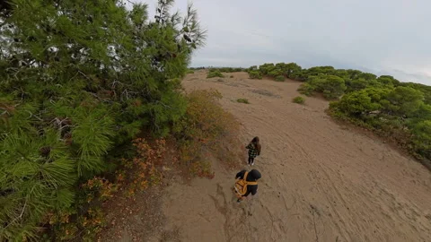 The camera focuses on the man with a yellow backpack and the woman walking on a Stock Footage 293094904