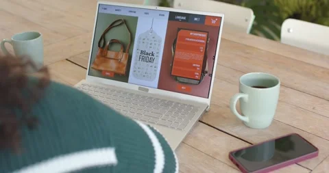Camera focusing is drawing shopper as she is viewing laptop showing Black Friday Stock Footage 342259151