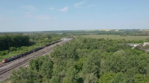 Camera follow towards passing train and distant lake. 스톡 동영상 111243587