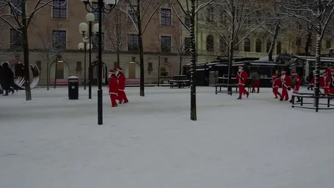 Camera following crowd of Santa Clauses running from side view to front view Stock Footage 70639535