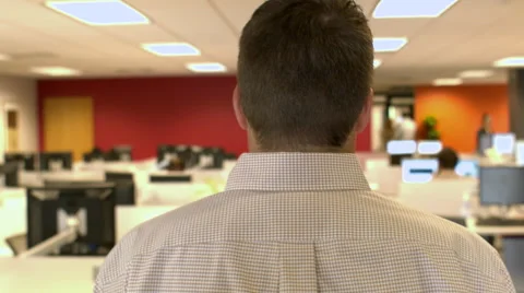 Camera following a man behind his head and shoulders walking through office Stock Footage 68242905
