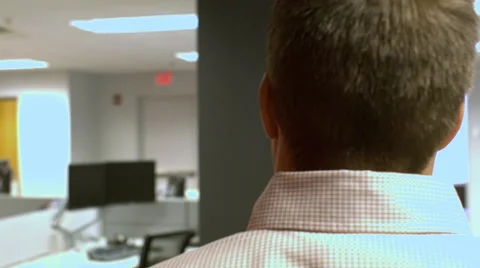 Camera following a man behind his head and shoulders walking through office Stock Footage 68243662