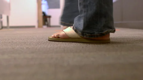 Camera following a man behind his feet walking through an office turning corner 動画素材 68249503